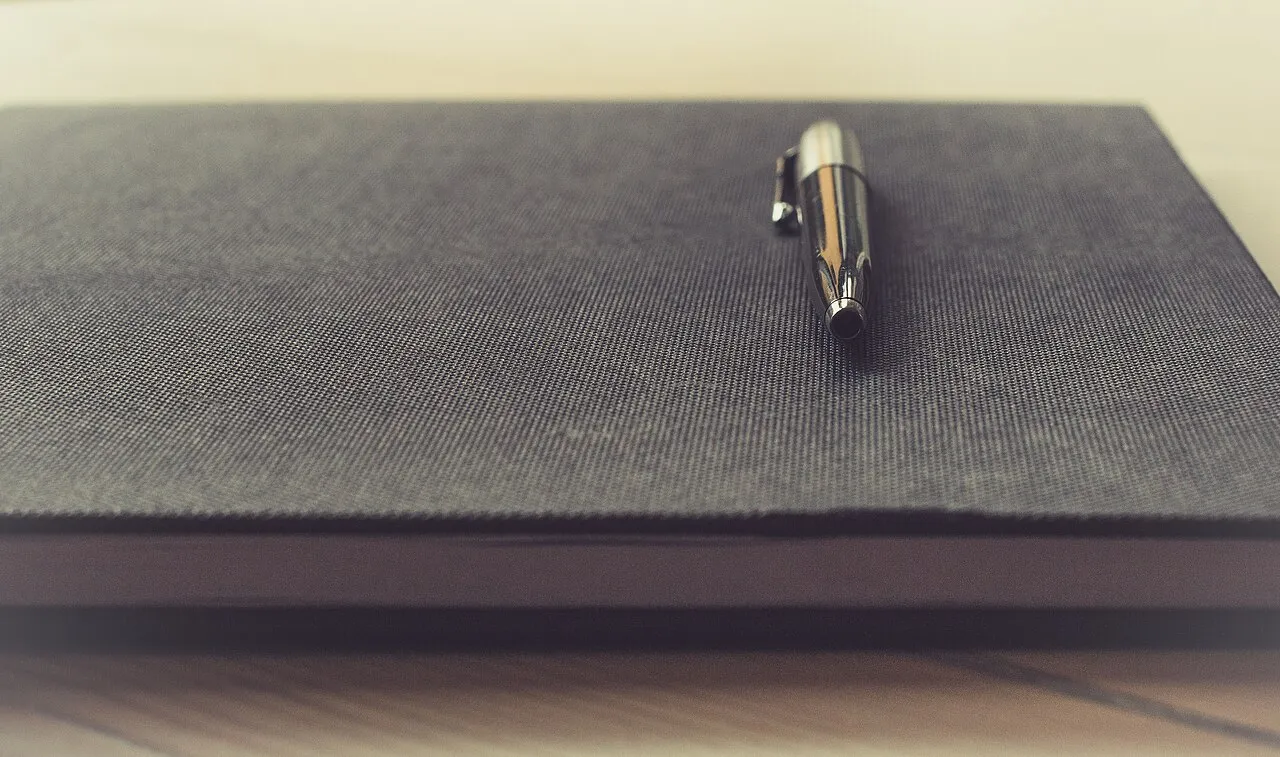 A pen resting on an open notebook